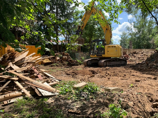 Bagger der Firma Stoll beim Abtragen und Planieren von Erdreich
